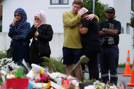 People embrace as they gather to pay respects after Friday's shooting, outside the Masjid Al Noor in Christchurch, New Zealand March 18, 2019. REUTERS/Jorge Silva