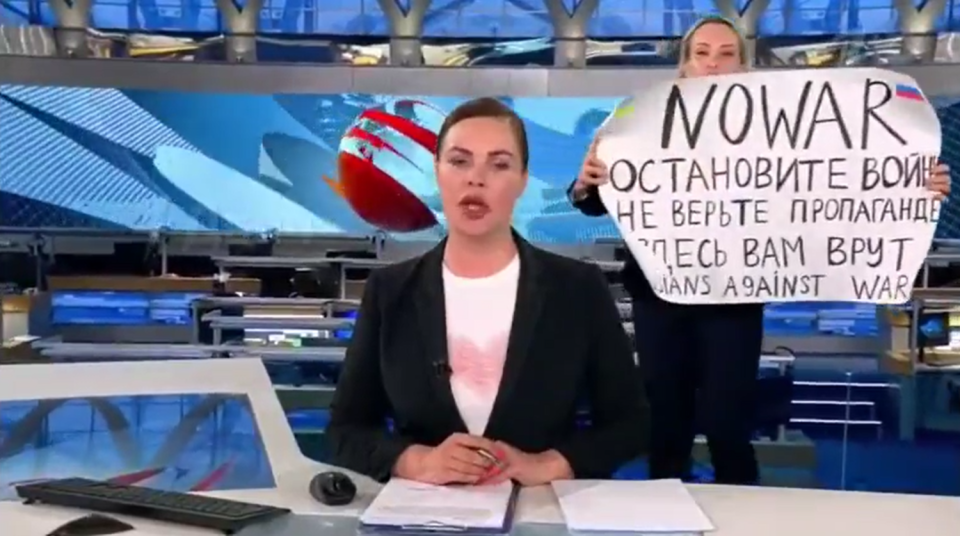 俄官媒編輯（右）在播報期間闖入高舉反戰標語遭逮捕，可能遭俄羅斯當局重判15年。   圖：翻攝自推特。