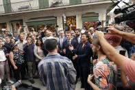 French President Emmanuel Macron claps to the performance of a street band as he walks down Royal St. in the French Quarter of New Orleans, Friday, Dec. 2, 2022. Right is New Orleans Mayor Latoya Cantrell. (AP Photo/Gerald Herbert)