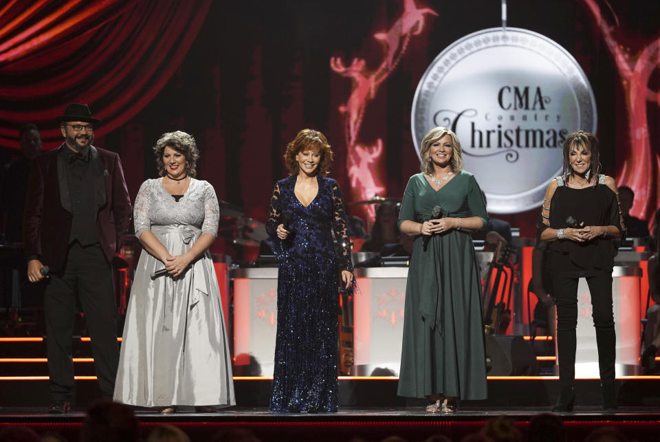 This image released by ABC shows host Reba McEntire, center, with members of The Isaacs, from left, Ben Isaacs, Becky Isaacs Bowman, Sonya Isaacs Yeary and Lily Isaacs during the ninth annual "CMA Country Christmas" airing Monday, Dec. 10, at 8 p.m. EST on ABC. (Mark Levine/ABC via AP)