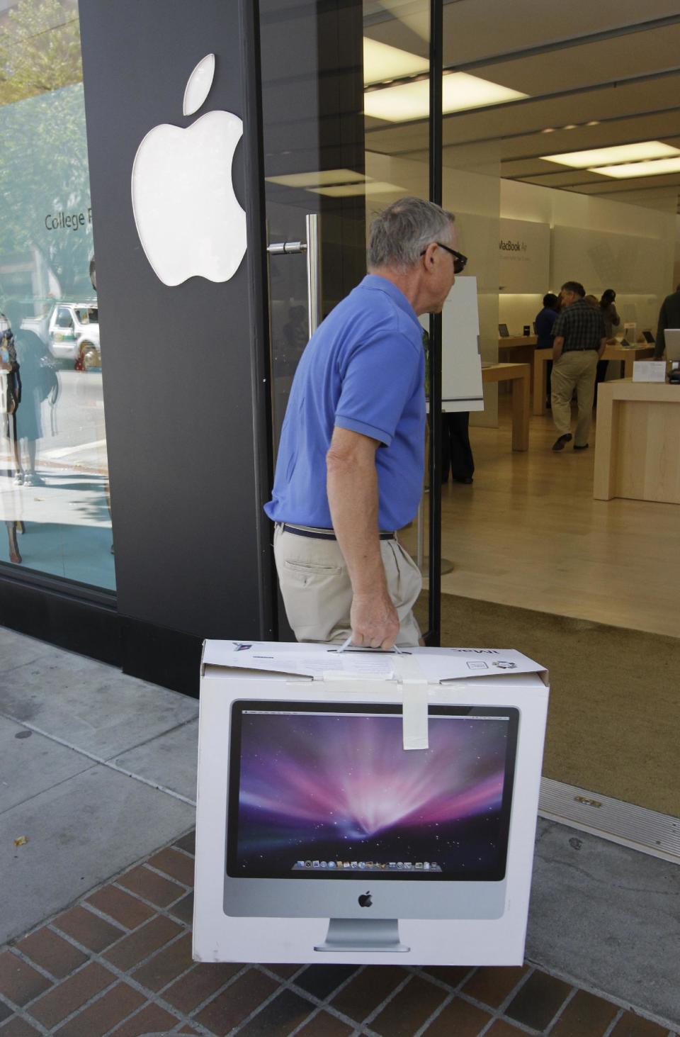 In this Thursday, July 19, 2012, photo, An Apple customer returns an Apple 21.5-inch iMac computer to an Apple store in Palo Alto, Calif. Apple Inc. reports quarterly financial results after the market closes on Tuesday, July 24. (AP Photo/Paul Sakuma)