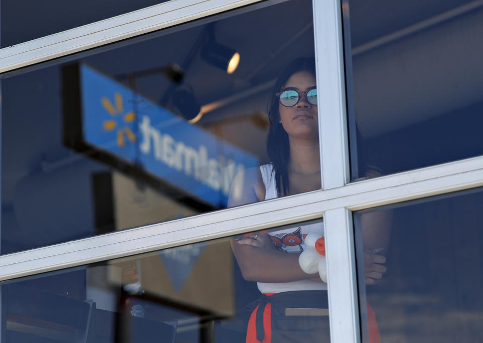 A restaurant employee looks at the scene of a mass shooting at a shopping complex Sunday, Aug. 4, 2019, in El Paso, Texas. (AP Photo/John Locher)