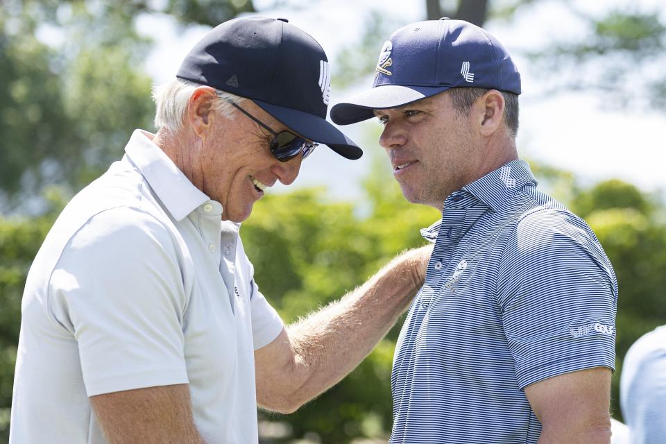 LIV Golf CEO Greg Norman interacts with Paul Casey of Crushers GC on the driving range before the second round of LIV Golf tournament at The Greenbrier, Saturday, Aug. 5, 2023, in White Sulfur Springs, W.Va. (Photo by Sam Greenwood/LIV Golf via AP)