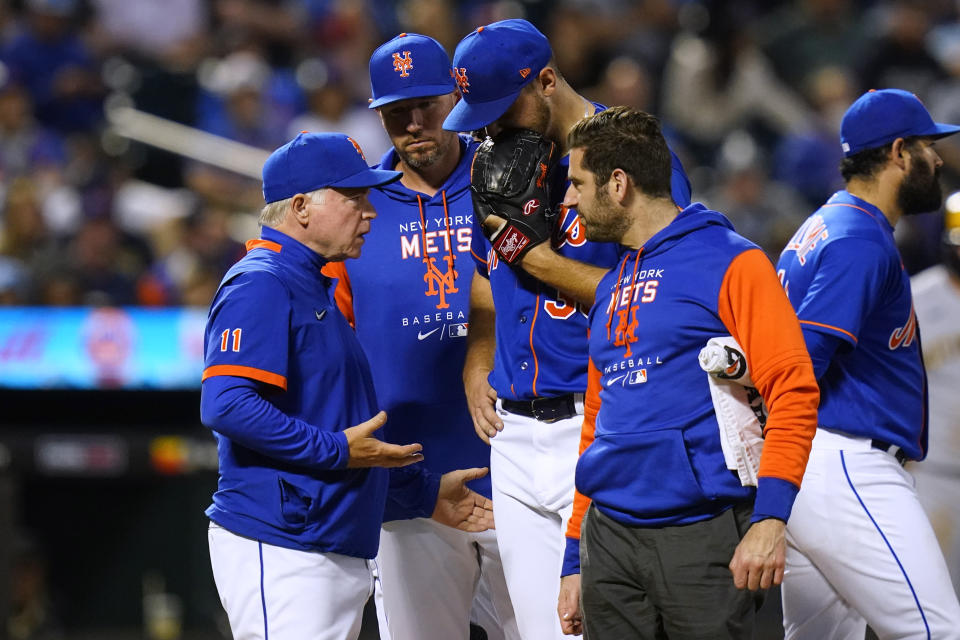 New York Mets manager Buck Showalter, left, talks to starting pitcher Tylor Megill, glove to face, who was pulled during the fourth inning of the team's baseball game against the Milwaukee Brewers on Thursday, June 16, 2022, in New York. (AP Photo/Frank Franklin II)