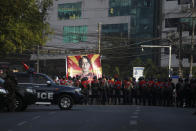 A large banner with an image of deposed Myanmar leader Aung San Suu Kyi faces rows of policemen blocking the road near the headquarters of the National League for Democracy party in Yangon, Myanmar Monday, Feb. 15, 2021. Security forces in Myanmar intensified their crackdown against anti-coup protesters on Monday, seeking to quell the large-scale demonstrations calling for the military junta that seized power earlier this month to reinstate the elected government. (AP Photo)