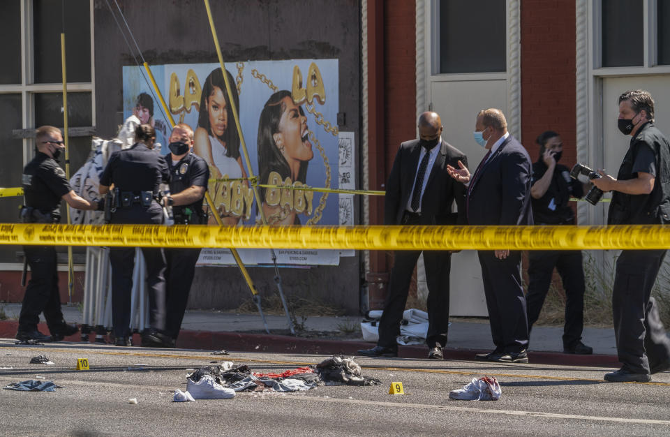 FILE - A photographer with the Los Angeles Police Department, far right, documents the remains of a crime scene in Beverly Hills, Calif., Friday, June 25, 2021. Homicides in California rose again last year, as did other violent crime, amid rising frustration as the state's top Democrats are seeking to keep their jobs in upcoming elections. (AP Photo/Damian Dovarganes, File)