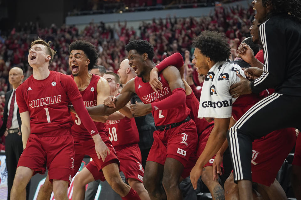 The Louisville bench celebrates a play during the second half of an NCAA college basketball game against Virginia Tech, Sunday, March 1, 2020 in Louisville, Ky. (AP Photo/Bryan Woolston)