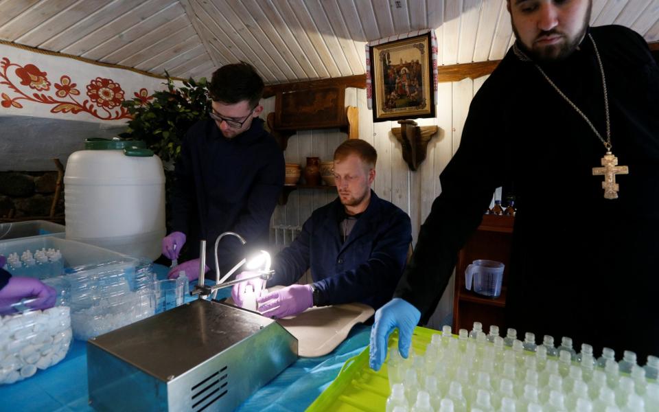 A clergyman of the Orthodox Church of Ukraine and students of the theological seminary produce hand sanitizer to donate it to the elderly and people in need to prevent the spread of coronavirus disease - REUTERS