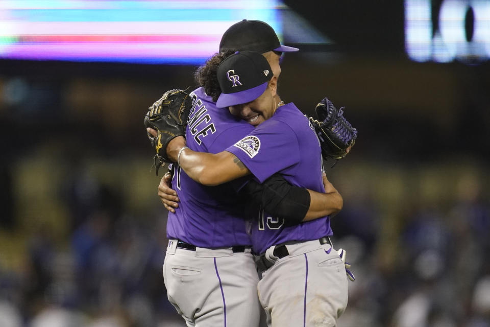 Colorado Rockies relief pitcher Justin Lawrence, left, hugs second baseman Alan Trejo (13) after their 2-1 win over the Los Angeles Dodgers in a baseball game in Los Angeles, Monday, Oct. 3, 2022. (AP Photo/Ashley Landis)