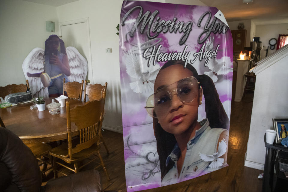 FILE - A cutout of twelve-year-old Todriana Peters sits in the dining room at the home of Bonnie Peters as Todriana's mother Katrina Lambert checks out a poster of her daughter in New Orleans, July 8, 2021. Three men have pleaded guilty in connection with a summer shooting that left a 12-year-old New Orleans girl dead and outraged the city. The Times-Picayune / The New Orleans Advocate reported that the parents of Todriana Peters were in the courtroom Wednesday, Oct. 27, 2021. (AP Photo/Sophia Germer)