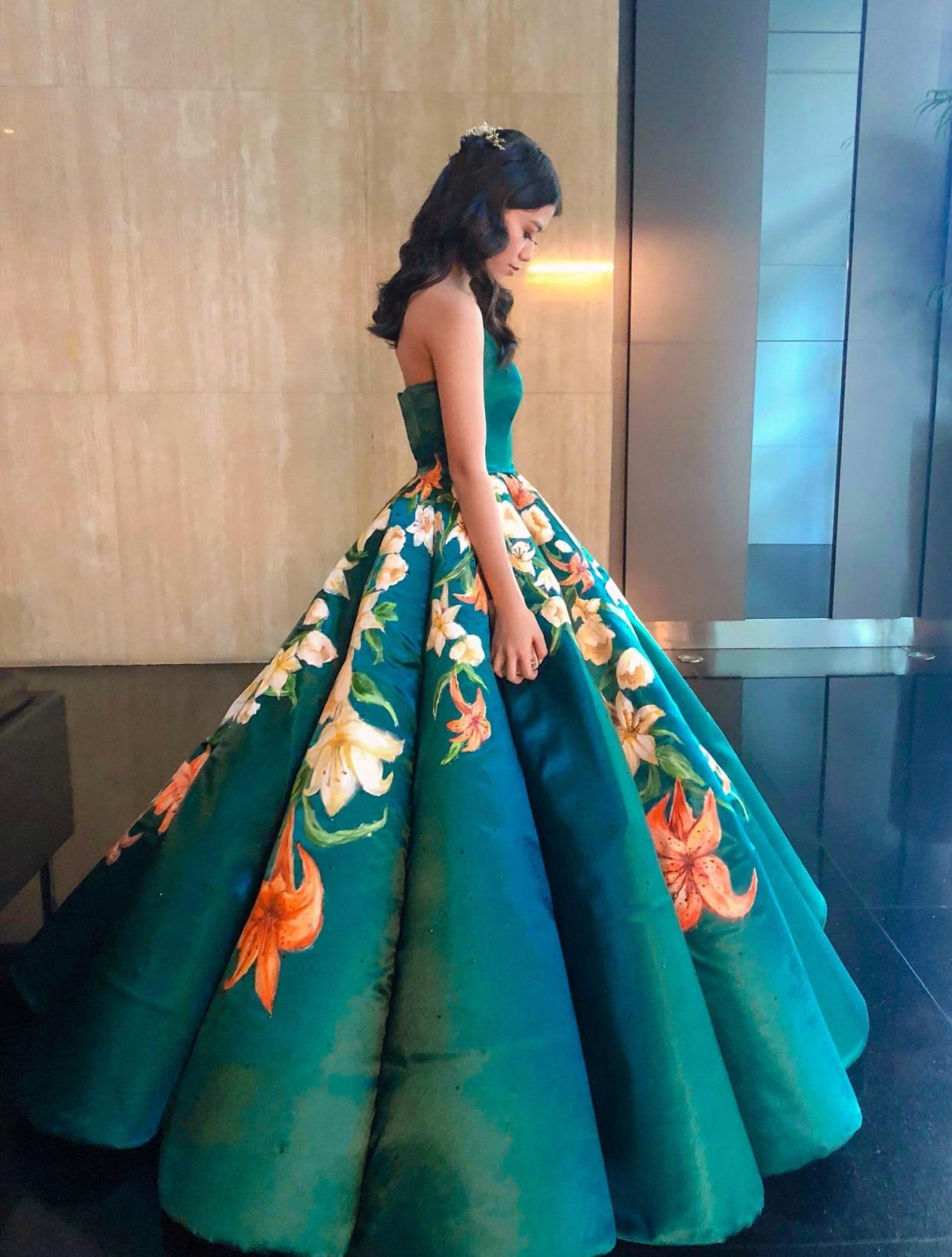 Ciara Gan, a recent high school graduate in the Philippines, poses with the dress that has been called an "absolute masterpiece" online. (Credit:Twitter/Ciara Gan)