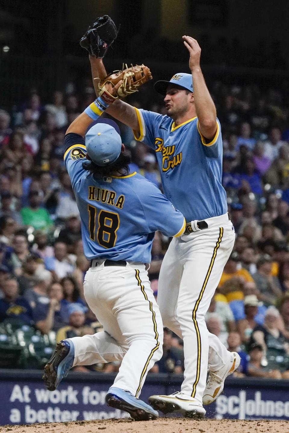 Milwaukee Brewers' Aaron Ashby colides with Keston Hiura as he catches a ball hit by Cincinnati Reds' Kyle Farmer during the fifth inning of a baseball game Saturday, Aug. 6, 2022, in Milwaukee. (AP Photo/Morry Gash)