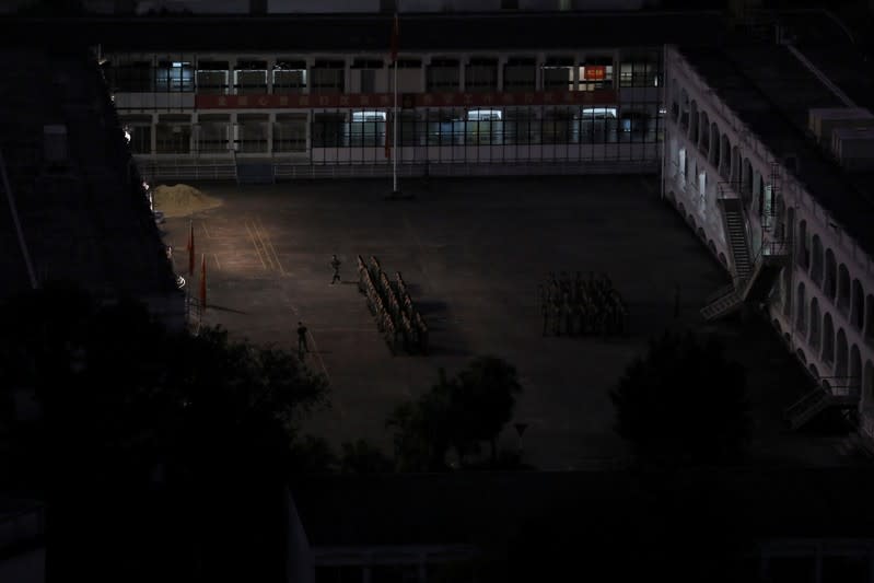 People's Liberation Army (PLA) soldiers stand in formation next to Hong Kong Polytechnic University