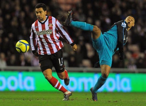 Sunderland's midfielder Kieran Richardson (L) clashes with Arsenal's striker Alex Oxlade-Chamberlain (R) during their FA Cup football match at The Stadium Of Light, in Sunderland. Arsenal's season of woe took another miserable turn on Saturday as the Premier League giants crashed out of the FA Cup in a 2-0 defeat at Sunderland