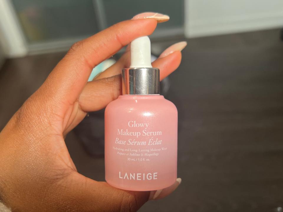 The writer holds a pink bottle with white "Laneige" text on it