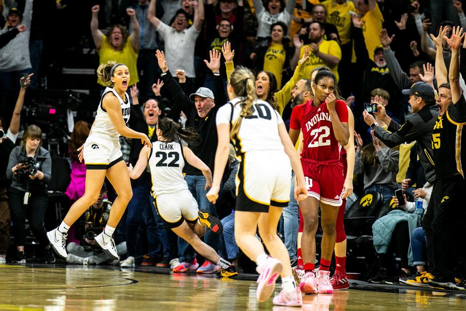 Iowa guards Gabbie Marshall, left, and Kate Martin celebrate the 3-point basket from teammate Caitlin Clark as Indiana guard Chloe Moore-McNeil, right, walks off the court after a NCAA Big Ten Conference women’s basketball game, Sunday, Feb. 26, 2023, at Carver-Hawkeye Arena in Iowa City, Iowa.