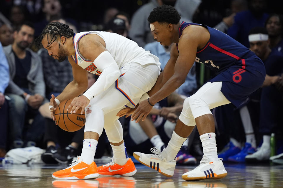 Philadelphia 76ers' Kyle Lowry, right, tries to get the ball from New York Knicks' Jalen Brunson during the second half of an NBA basketball game, Thursday, Feb. 22, 2024, in Philadelphia. (AP Photo/Matt Slocum)