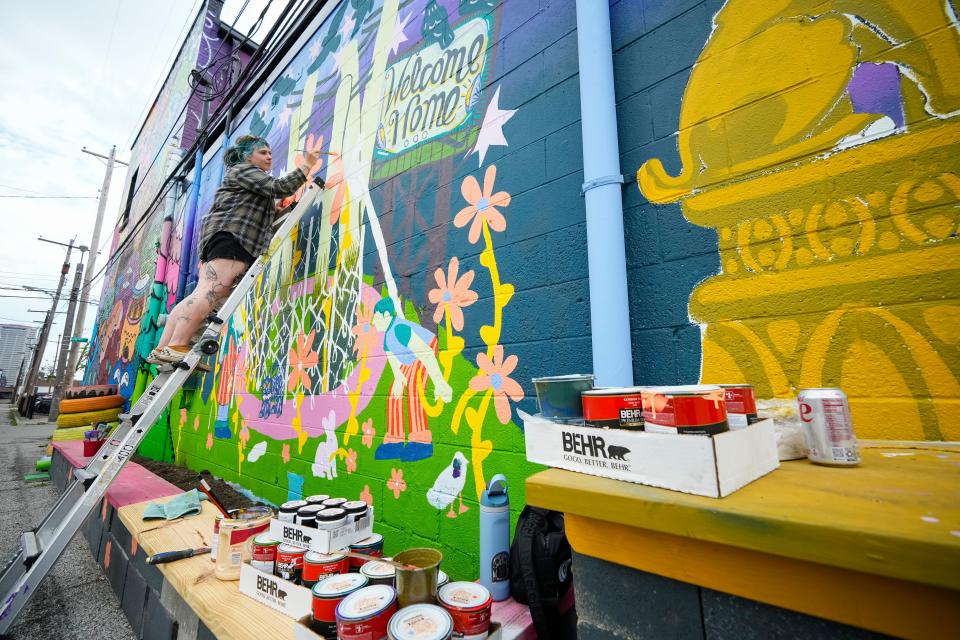 Elaina Workley of Grove City creates a mural in the alley of Lafayette Street, between Fourth Street and Grant Avenue, for the Alley Islands Street Festival.