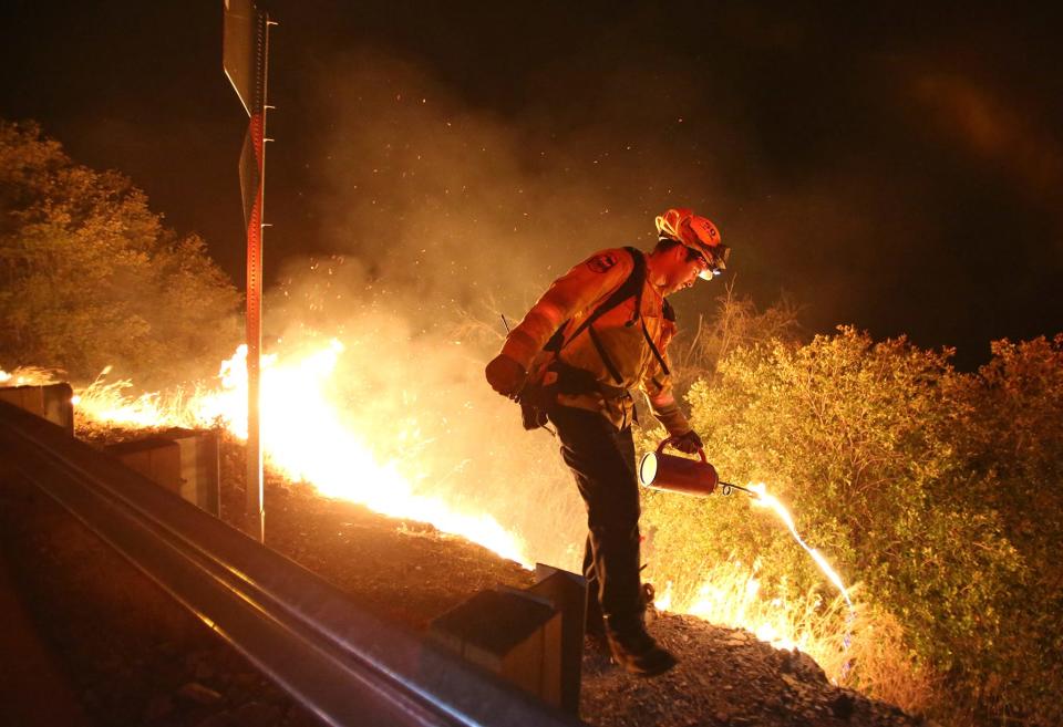 A California Department of Forestry and Fire Protection firefighter initiates a backburn on Aug. 18, 2020, near Grass Valley, California.