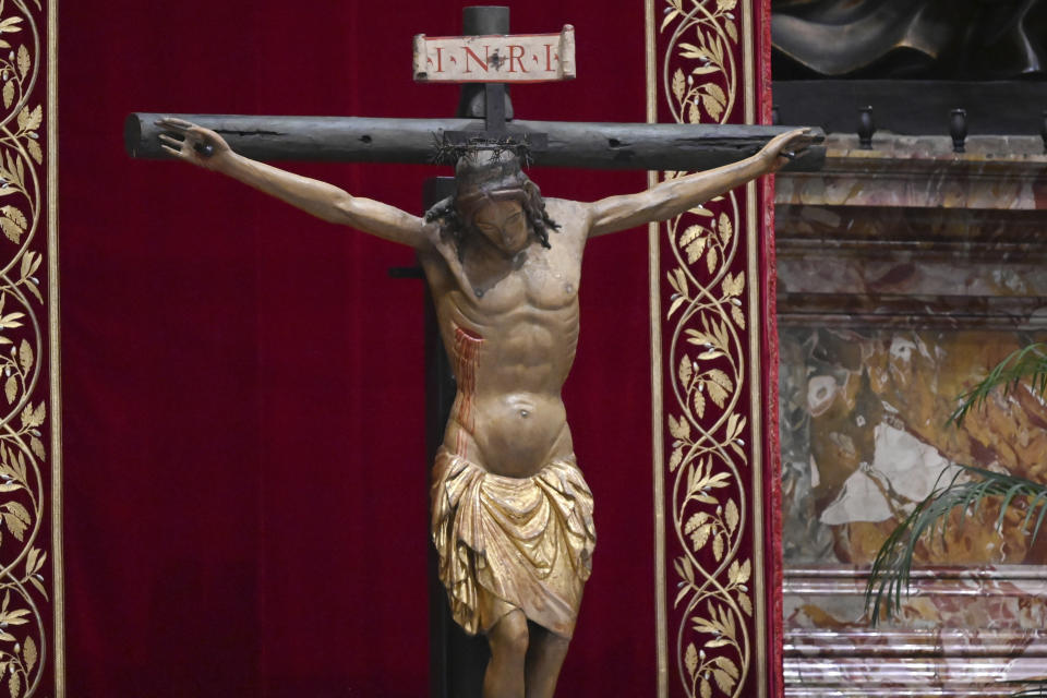 A miraculous crucifix that in 1552 was carried in a procession around Rome to stop the great plague, is seen during Palm Sunday Mass behind closed doors in St. Peter's Basilica, at the Vatican, Sunday, April 5, 2020, during the lockdown aimed at curbing the spread of the COVID-19 infection, caused by the novel coronavirus. (AP Photo/pool/Alberto Pizzoli)