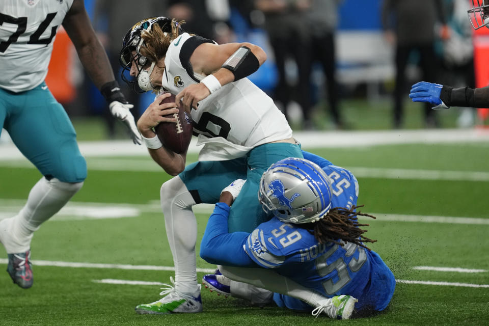 Jacksonville Jaguars quarterback Trevor Lawrence (16) is sacked by Detroit Lions linebacker James Houston (59) during the first half of an NFL football game, Sunday, Dec. 4, 2022, in Detroit. (AP Photo/Paul Sancya)