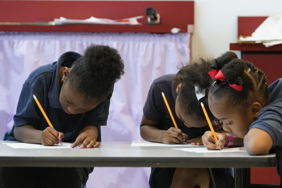 Second grade students write during class at Schaumburg Elementary, part of the ReNEW charter network, in New Orleans, Wednesday, April 19, 2023. (AP Photo/Gerald Herbert)