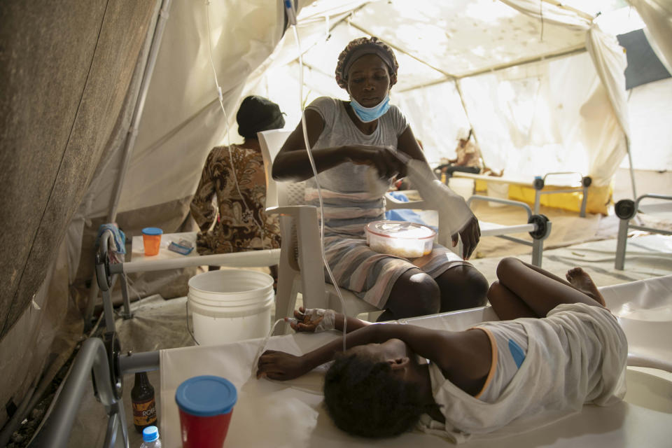 A woman uses a towel to swat flies away from her daughter stricken with cholera, at a clinic run by Doctors Without Borders in Port-au-Prince, Haiti, Friday, Nov. 11, 2022. (AP Photo/Odelyn Joseph)