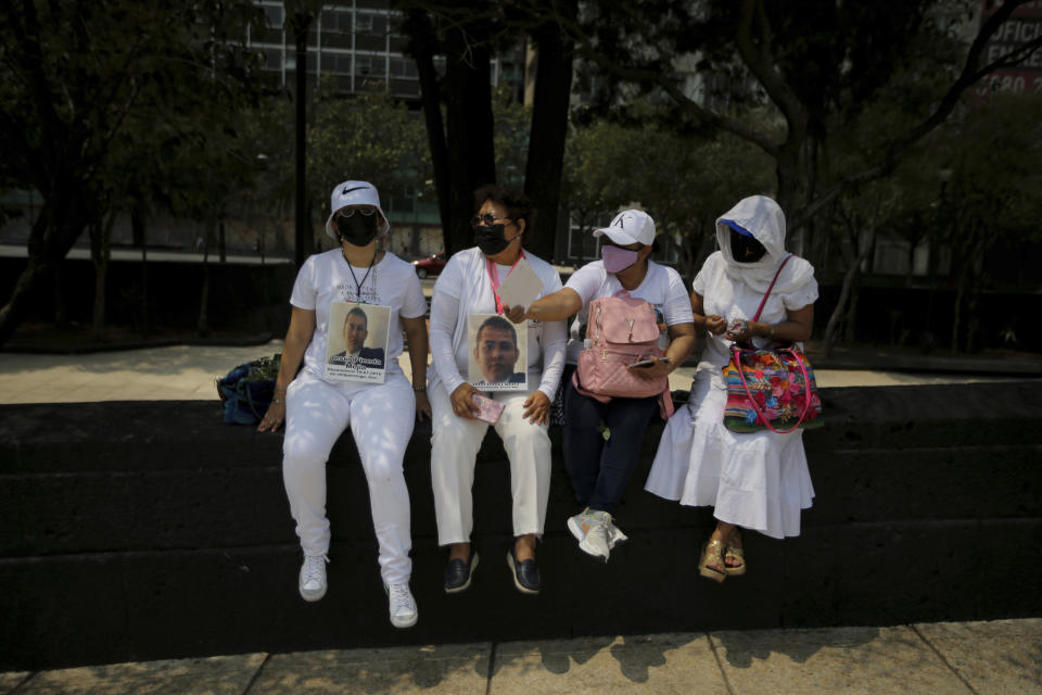 The relatives of disappeared people sit on the sidelines of a march in remembrance of those who have disappeared, on Mother's Day in Mexico City, Monday, May 10, 2021. (AP Photo/Fernando Llano)