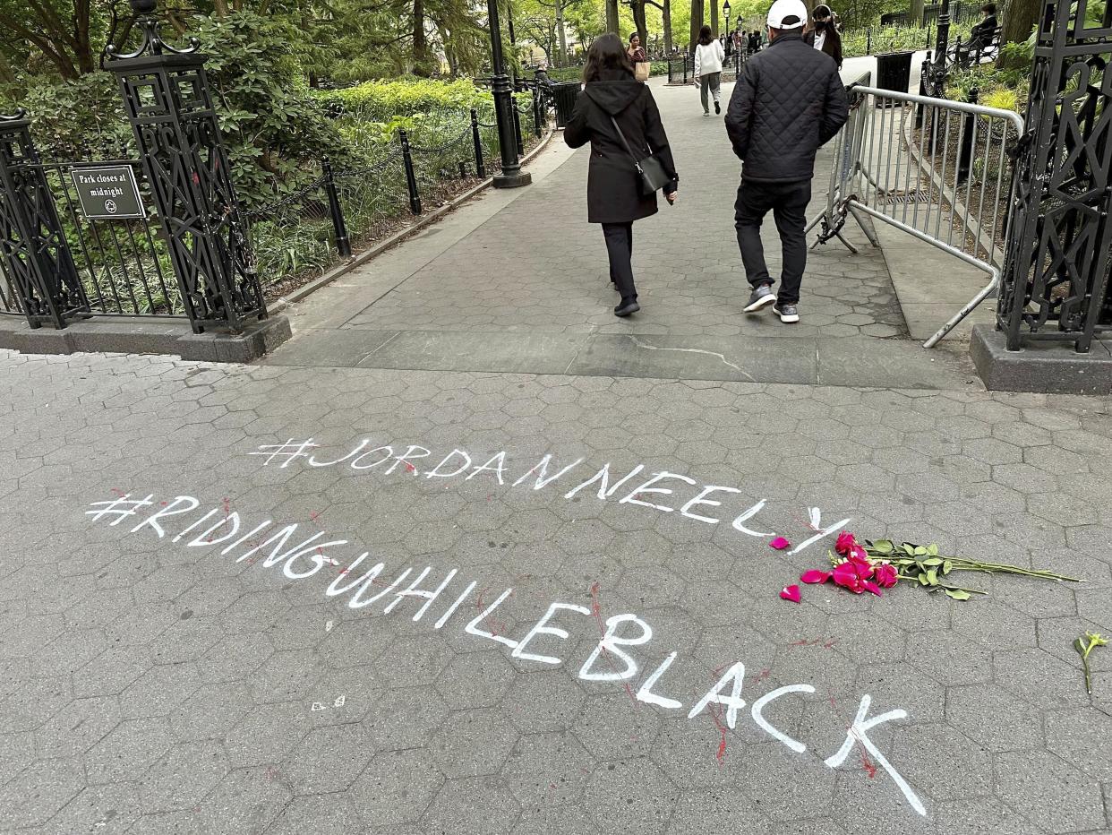 FILE - People walk past graffiti calling attention to death of Jordan Neely that was painted on the sidewalk at an entrance to Washington Square Park, Friday, May 5, 2023, in New York. Manhattan prosecutors said Thursday, May 11, 2023, that they will bring criminal charges against Daniel Penny, the man who used a deadly chokehold on Neely, an unruly passenger, aboard a New York City subway train. The incident stirred outrage and debates about the response to mental illness in the nation’s largest transit system. (AP Photo/Brooke Lansdale, File)