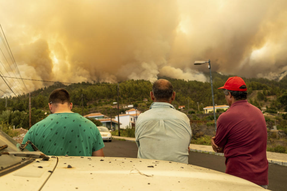 Local residents look on at a burning forest fire, near Puntagorda on the Canary Island of La Palma, Saturday, July 15, 2023. Spanish authorities say that they have preemptively evacuated some 500 people to avoid a wildfire that has broken out on the Canary island of La Palma. The fire coincides with a heatwave that is hitting southern Europe. Spain recorded record high temperatures in 2022 and this spring as it endures a prolonged drought. (Europa Press via AP)