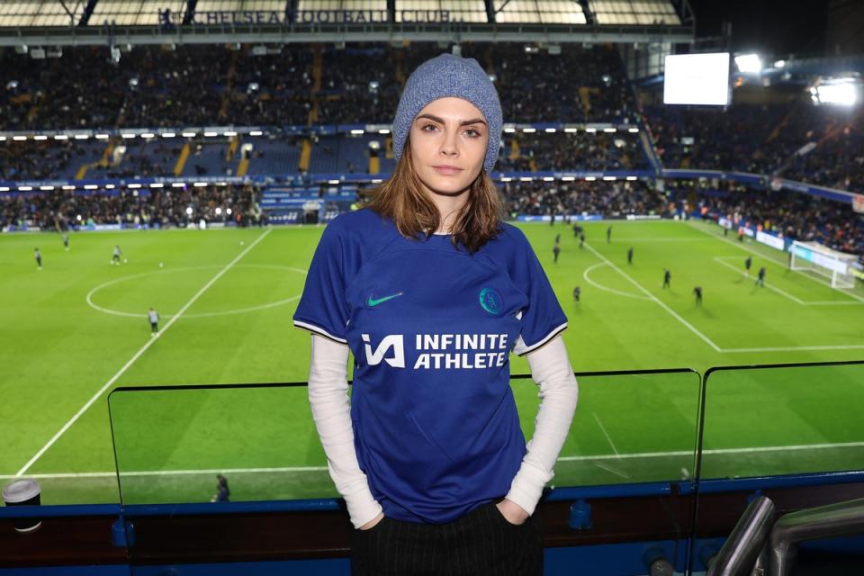 Actress Cara Delevingne poses for a photograph while wearing a Chelsea shirt during a match at Stamford Bridge  (Chelsea FC via Getty Images)