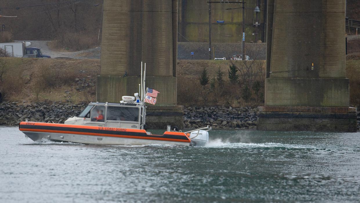 A U.S. Coast Guard patrol boat heads east through the Cape Cod Canal past the cement support columns for the Sagamore Bridge in Bourne.