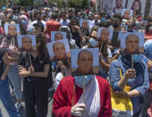 Angry demonstrators carry pictures of Nizar Banat, an outspoken critic of the Palestinian Authority, and chant anti-PA slogans during a rally protesting his death, in the West Bank city of Ramallah, Thursday, June 24, 2021. Banat who was a candidate in parliamentary elections called off earlier this year died after Palestinian security forces arrested him and beat him with batons on Thursday, his family said. (AP Photo/Nasser Nasser)