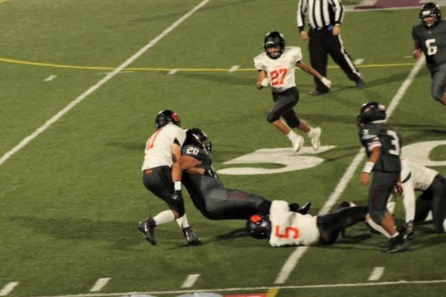 Aztec Tigers Baylor Seabolt (5) and Dennis  Barnes (17) bring down a Shiprock ball carrier during a game at Shiprock High School, Friday, Oct. 1, 2021.