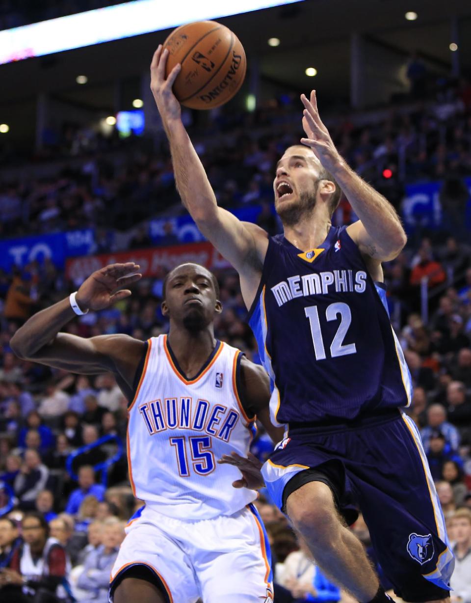 Memphis Grizzlies guard Nick Calathes (12) goes to the basket in front of Oklahoma City Thunder guard Reggie Jackson (15) during the first quarter of an NBA basketball game on Monday, Feb. 3, 2014, in Oklahoma City. (AP Photo/Alonzo Adams)
