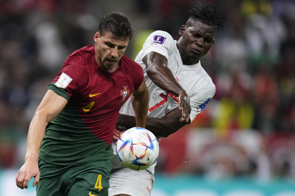 Portugal's Ruben Dias, left, is challenged by Switzerland's Breel Embolo during the World Cup round of 16 soccer match between Portugal and Switzerland, at the Lusail Stadium in Lusail, Qatar, Tuesday, Dec. 6, 2022. (AP Photo/Manu Fernandez)