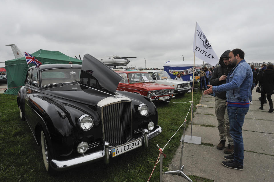 Visitors are seen admiring the Bentley S2 car of 1952 during the Old Car Land Festival at the Aviation Museum in Kiev. (Photo by Sergei Chuzavkov / SOPA Images/Sipa USA)