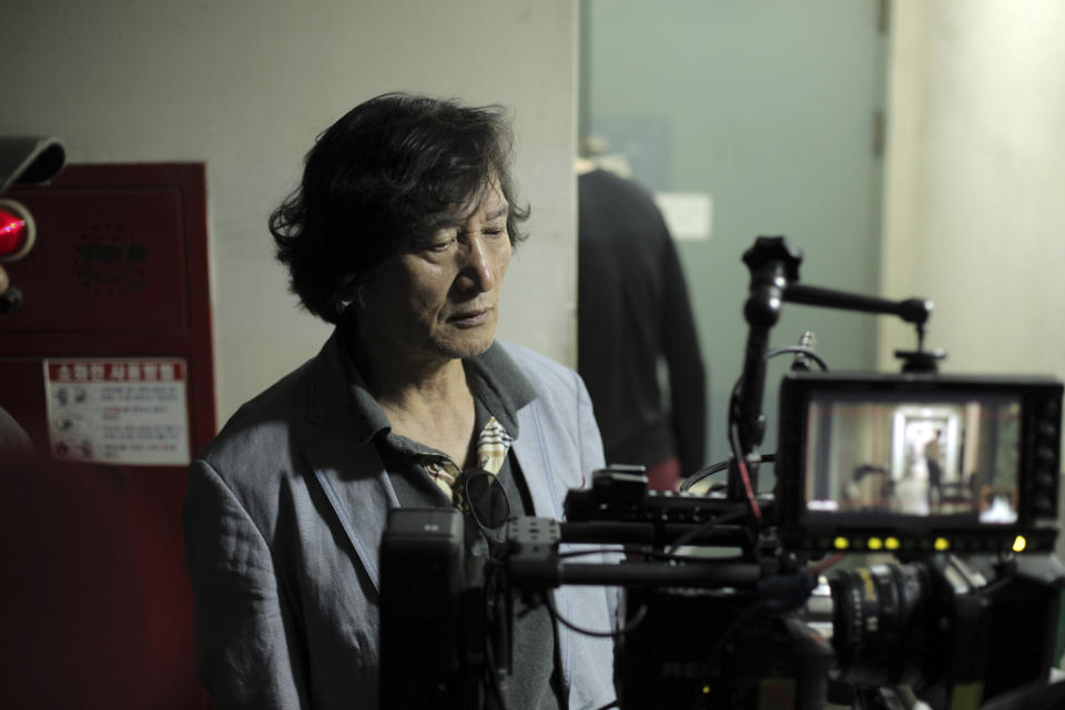 In this undated photo released on Friday, Oct. 5, 2012 by Busan International Film Festival, South Korean director Chung Ji-young looks at a monitor for his movie "National Security" in South Korea. The film based on the memoir of a democracy activist who was tortured in the 1980s by South Korea's military rulers is provoking discussion about the country's not-so-distant authoritative past and the influence it will have on this year's presidential election. (AP Photo/Busan International Film Festival) EDITORIAL USE ONLY