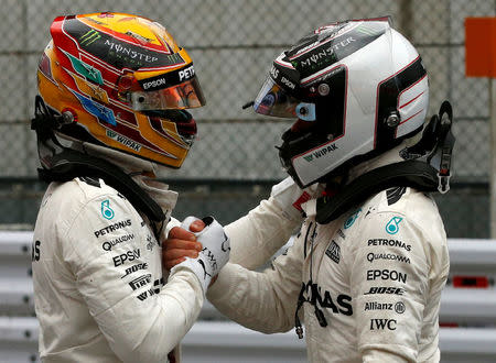 Formula One F1 - Japanese Grand Prix 2017 - Suzuka Circuit, Japan - October 7, 2017. Mercedes' Lewis Hamilton (L) of Britain celebrates with Valtteri Bottas of Finland after getting pole position in qualifying. REUTERS/Toru Hanai