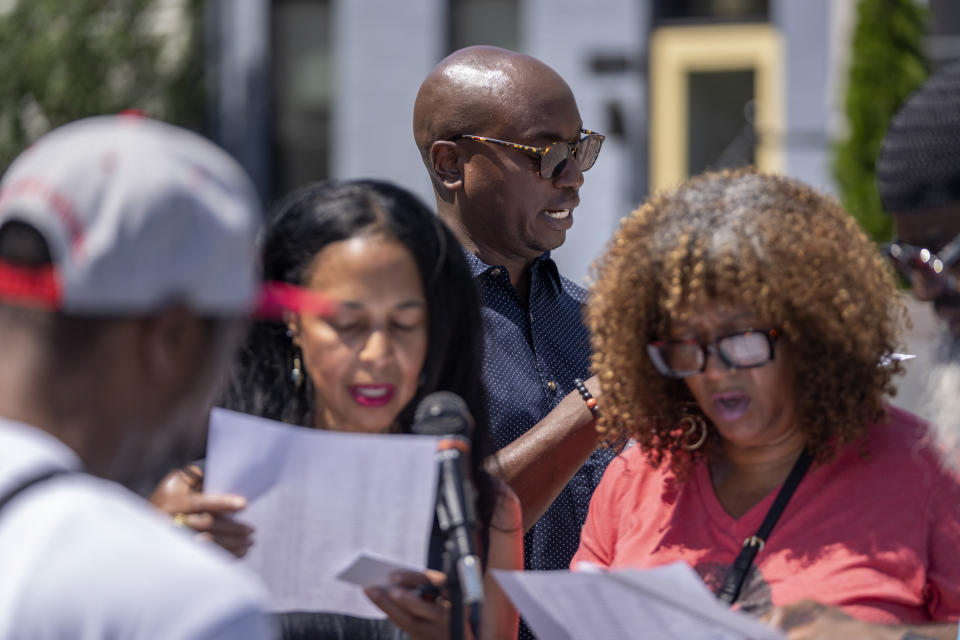 Associated Press reporter Darren Sands, second from right, reads the names of United States Colored Troops regimental soldiers, including his great-great-great-great grandfather Hewlett Sands, at the African American Civil War Memorial as part of Juneteenth commemorations on Wednesday, June 19, 2024, in Washington. (AP Photo/Mark Schiefelbein)