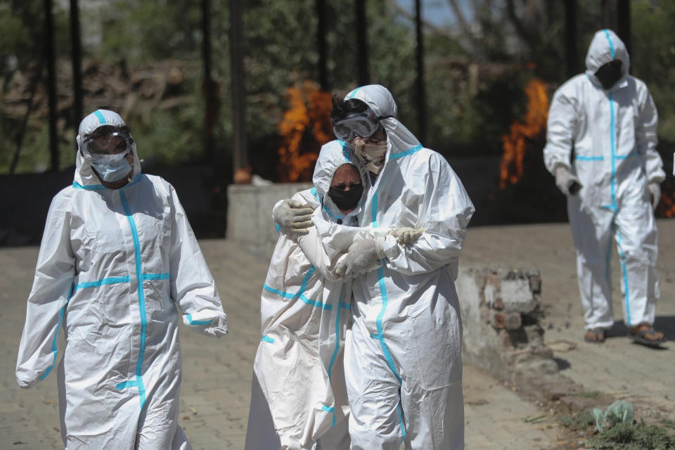 FILE - A relative of a person who died of COVID-19 is consoled by another during cremation in Jammu, India, Sunday, April 25, 2021. The World Health Organization is estimating that nearly 15 million people were killed either by the coronavirus or by its impact on overwhelmed health systems in the past two years. That is more than double its official death toll. The U.N. health agency says most of the fatalities were in Southeast Asia, Europe and the Americas. In a report released Thursday, May 5, 2022 WHO chief Tedros Adhanom Ghebreyesus describes the figure as “sobering." (AP Photo/Channi Anand, File)