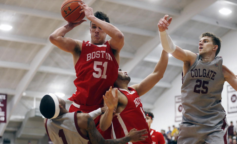 Boston University's Max Mahoney (51) grabs a rebound over Colgate's Jordan Burns (1) in the second half of the NCAA Patriot League Conference basketball championship at Cotterell Court, Wednesday, March 11, 2020, in Hamilton, N.Y. (AP Photo/John Munson)