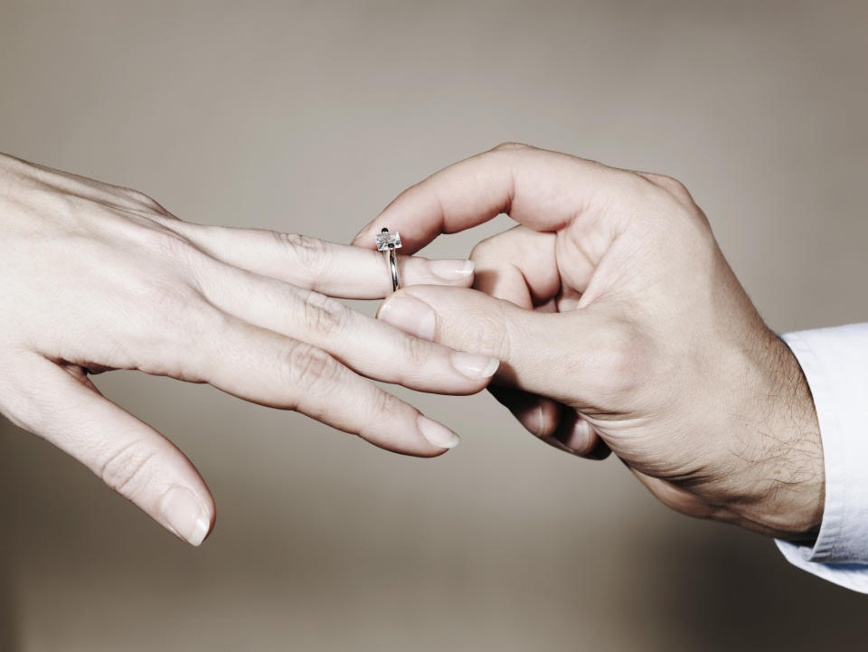 hands putting a ring on a finger