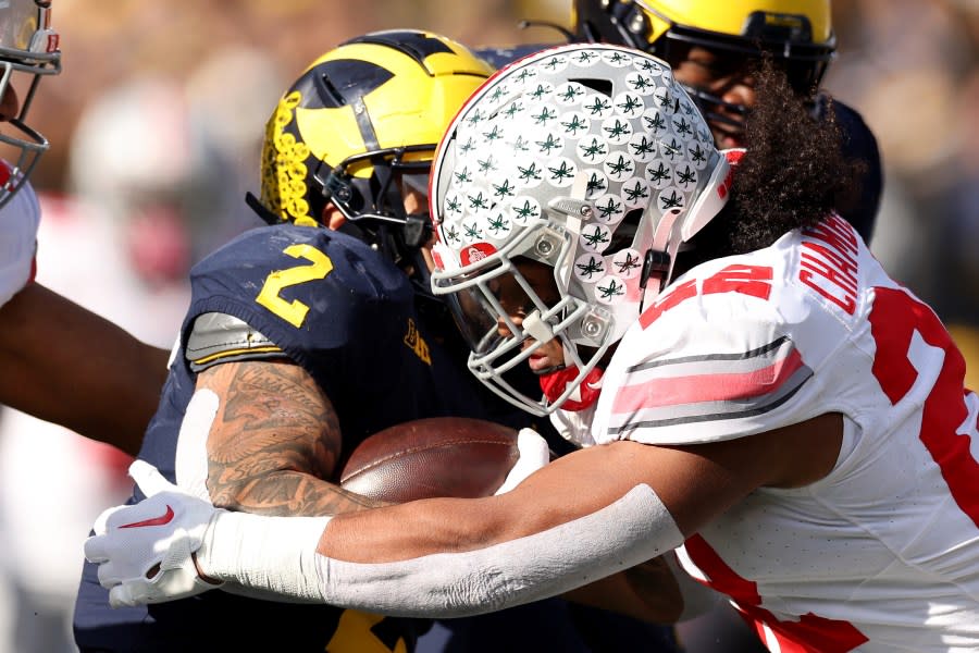 ANN ARBOR, MICHIGAN – NOVEMBER 25: Steele Chambers #22 of the Ohio State Buckeyes tackles Blake Corum #2 of the Michigan Wolverines during the first quarter in the game at Michigan Stadium on November 25, 2023 in Ann Arbor, Michigan. (Photo by Ezra Shaw/Getty Images)
