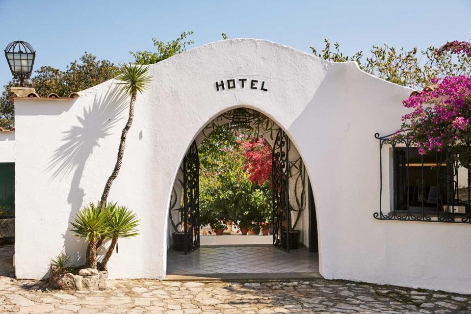 White arched entrance to the Hotel Punta Rossa, on Monte Circeo, in Italy