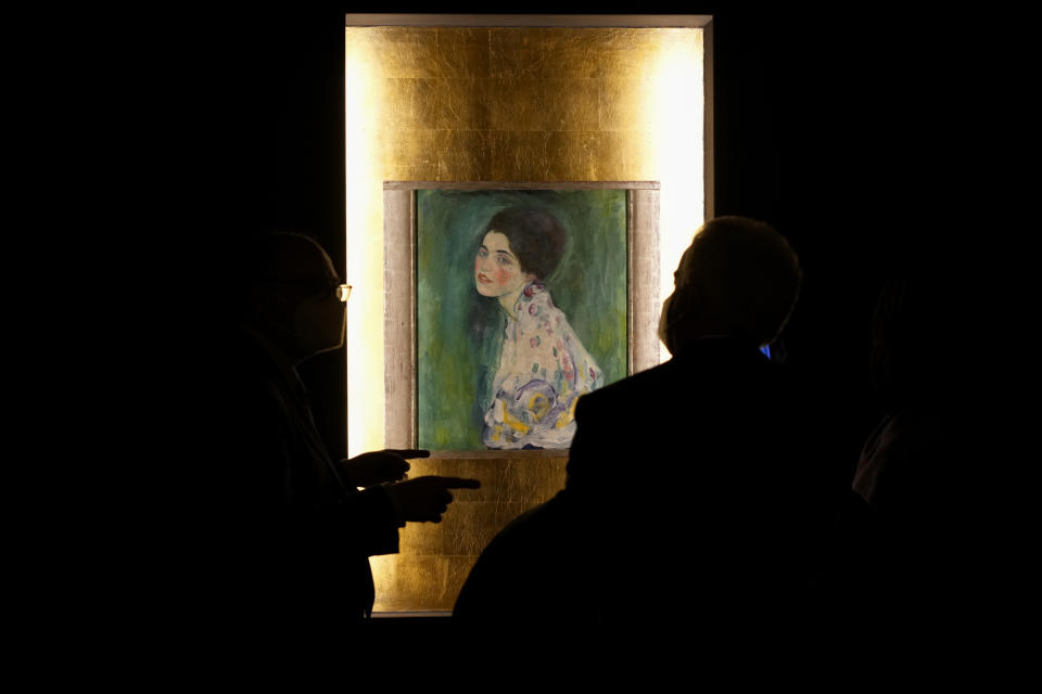 People admire Gustav Klimt's oil on canvas painting "Portrait of a Lady" (1916/17) on display at the exhibition "Klimt. The Secession and Italy" at the Museum of Rome, in Palazzo Braschi, Rome, during a press preview, Tuesday, Oct. 26, 2021. The exhibition, that explores Klimt's period in Italy, will be open to visitors from Oct.27, 2021 to March 27, 2022. (AP Photo/Andrew Medichini)