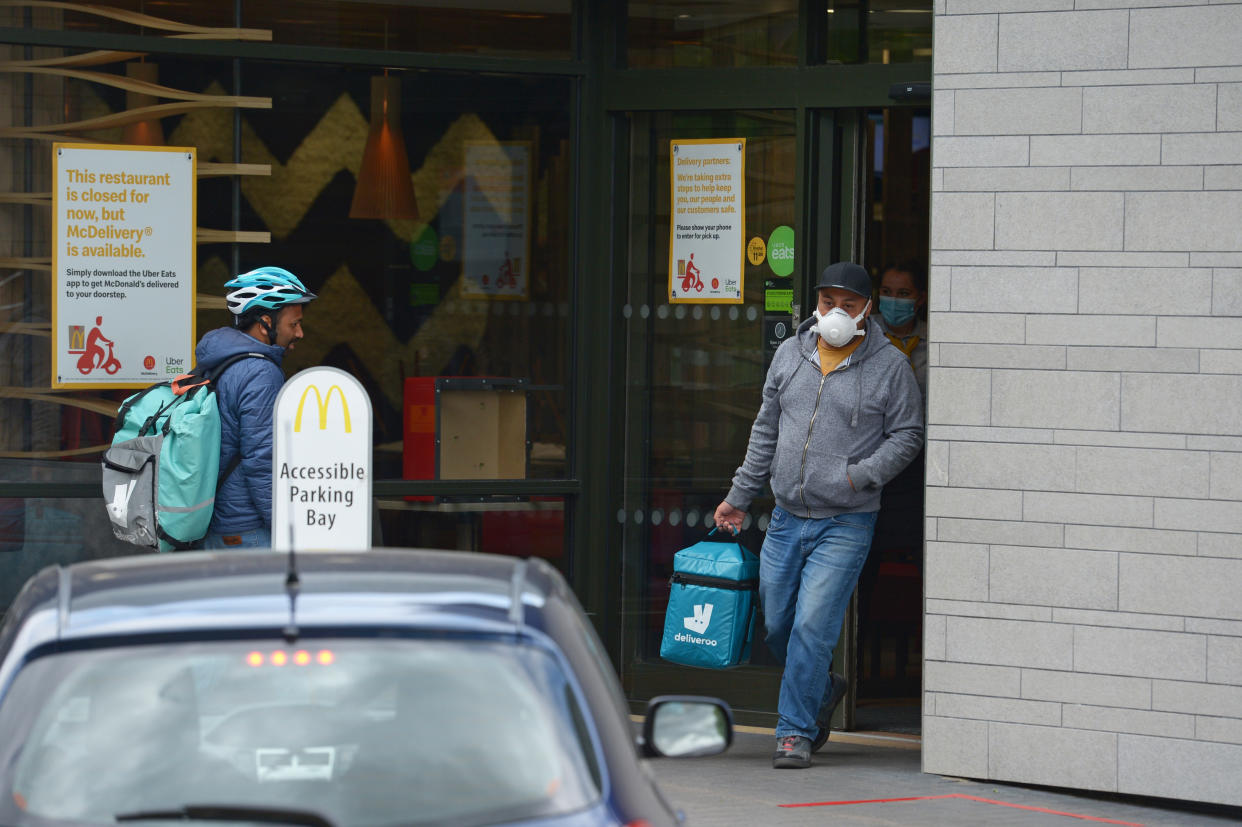 Deliveroo workers at a branch of McDonald's in Boreham, Chelmsford, Essex, one of 15 of the restaurant chain locations to have reopened for takeaway.