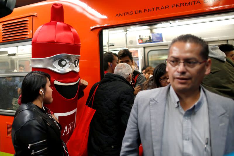 A man wearing a costume, representing a condom, is seen at a metro station, on the International Condoms Day, celebrated a day before Valentine Day, in Mexico City