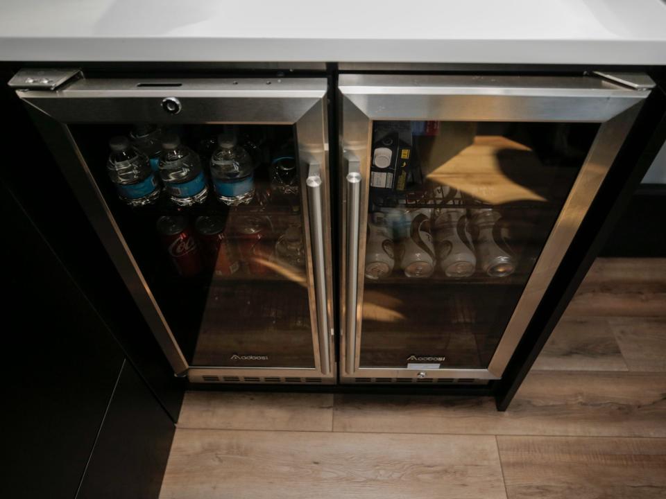 A fridge with tinted windows and drinks inside.