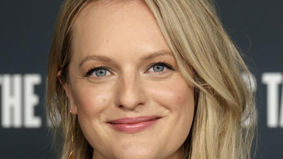 elisabeth moss smiling for a photograph at a watch event